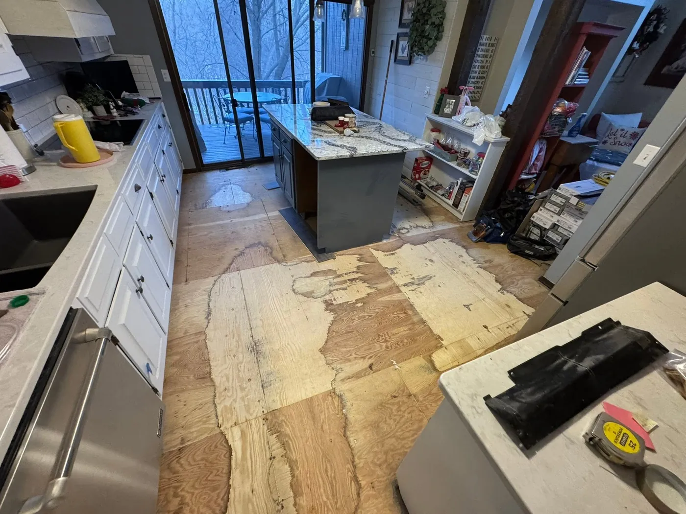 Kitchen with the old floor torn out down to bare subfloor before new flooring